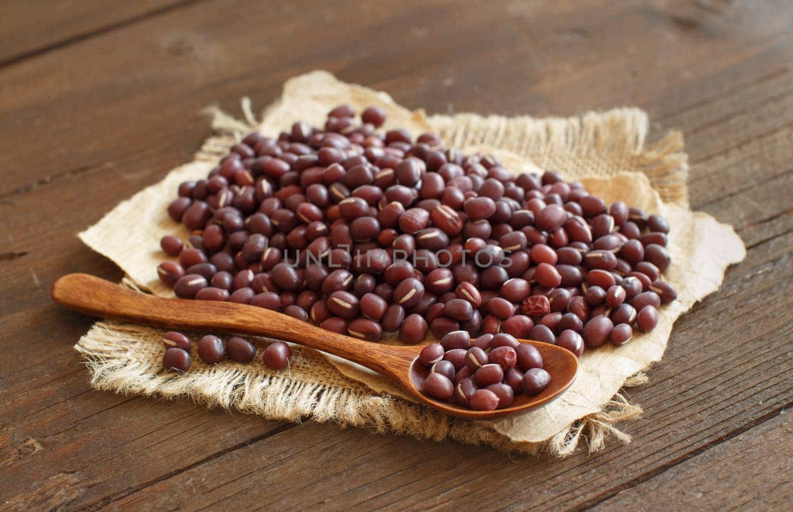 Raw azuki beans with a spoon on a wooden table