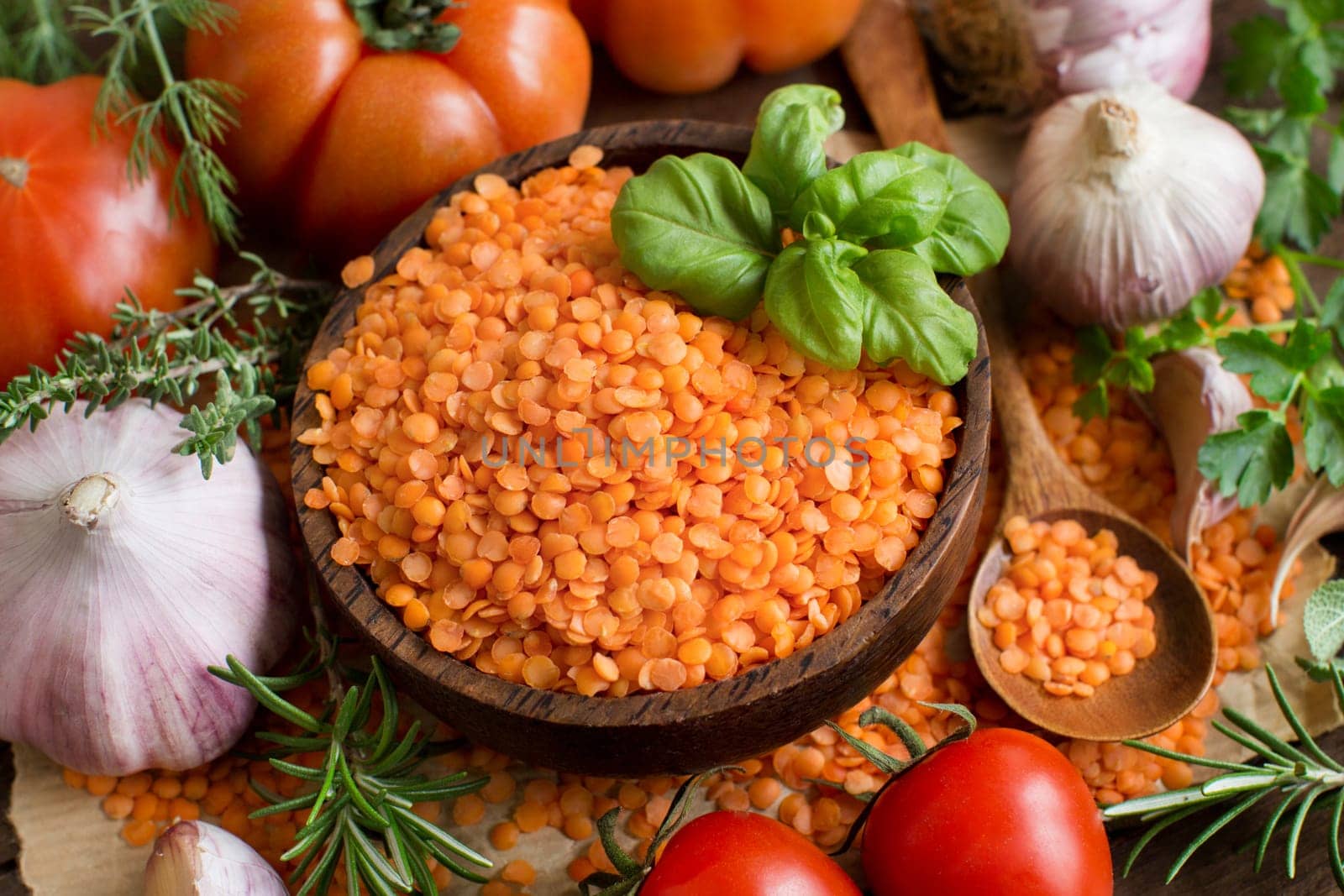 Red lentils in a bowl with tomatoes, garlic and herbs top view