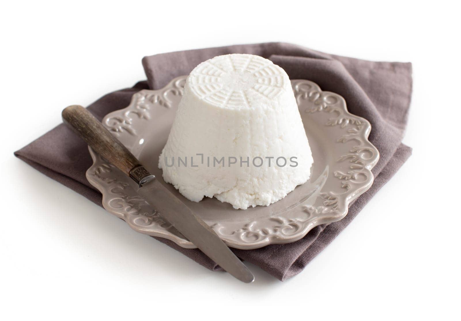 Italian ricotta cheese with knife on napkin isolated on white