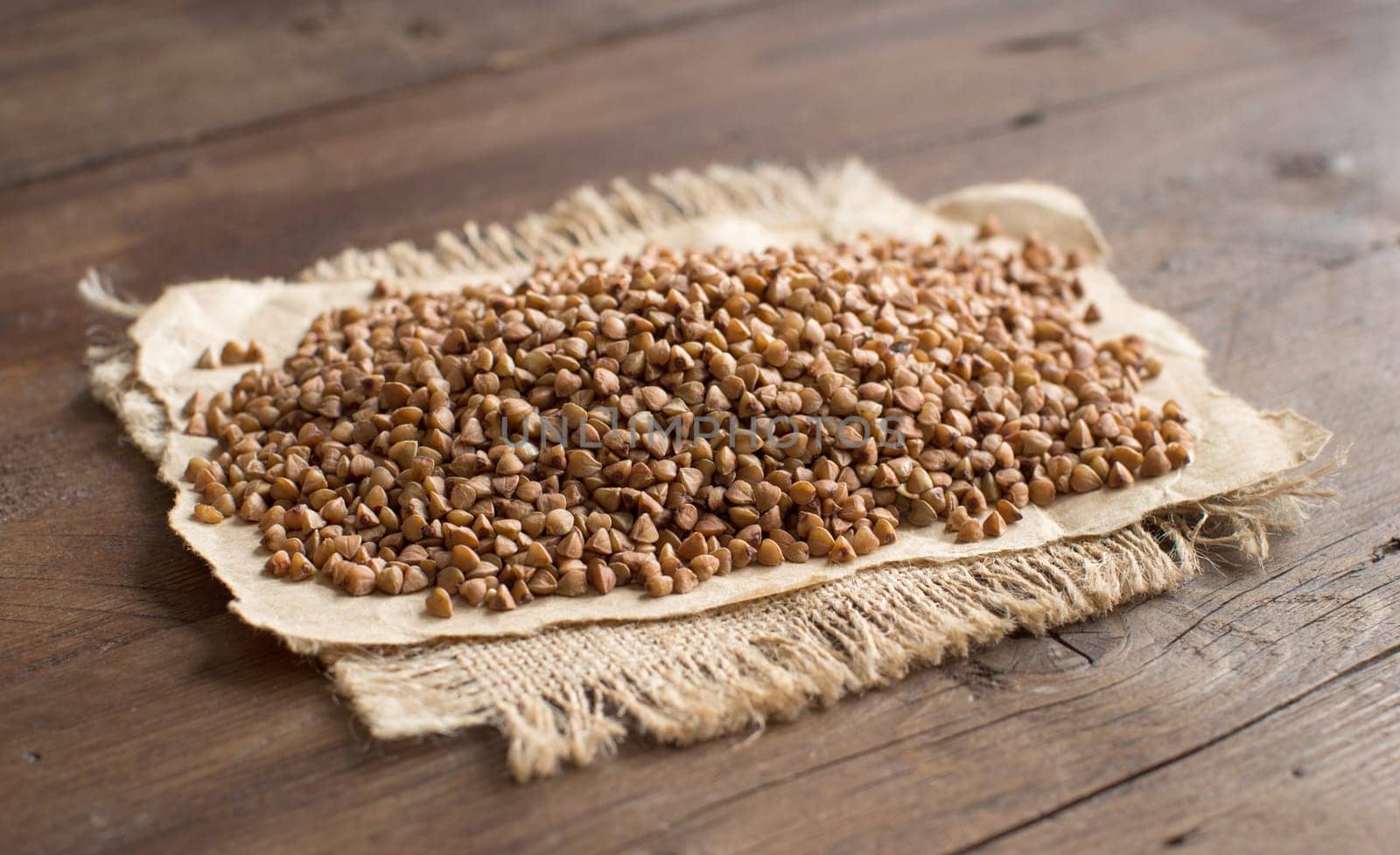 A pile of buckwheat on a wooden table
