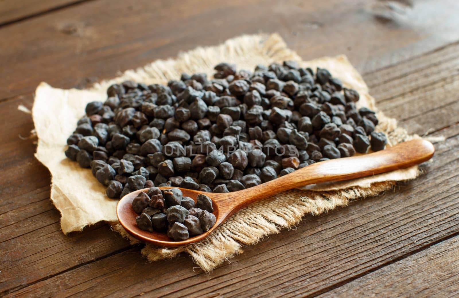 Black Chickpea with a spoon on a wooden table close up