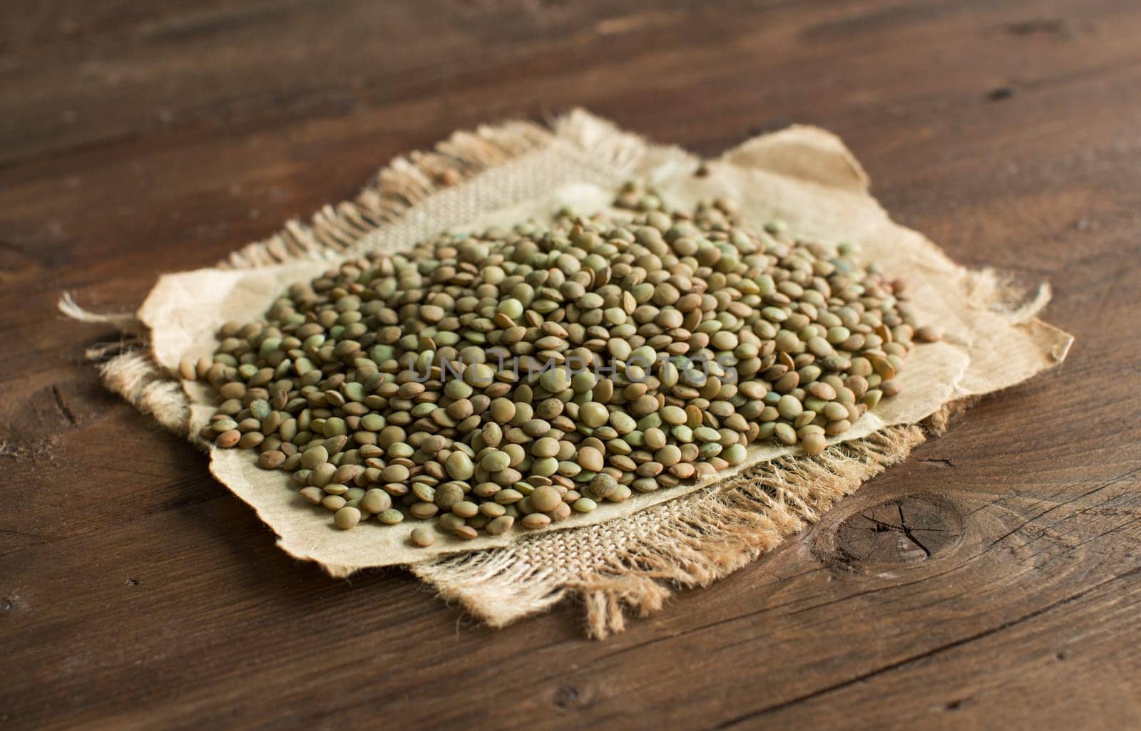 Pile of green lentilson a wooden table