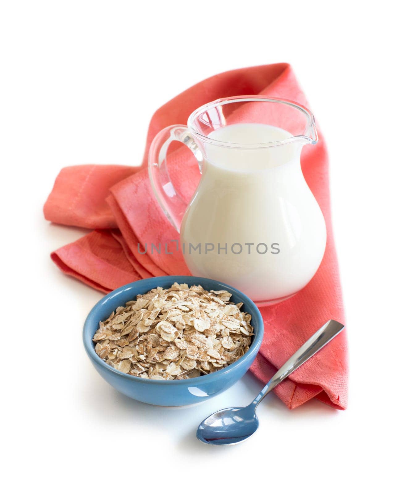 Rolled oats in a bowl and milk on a wooden table