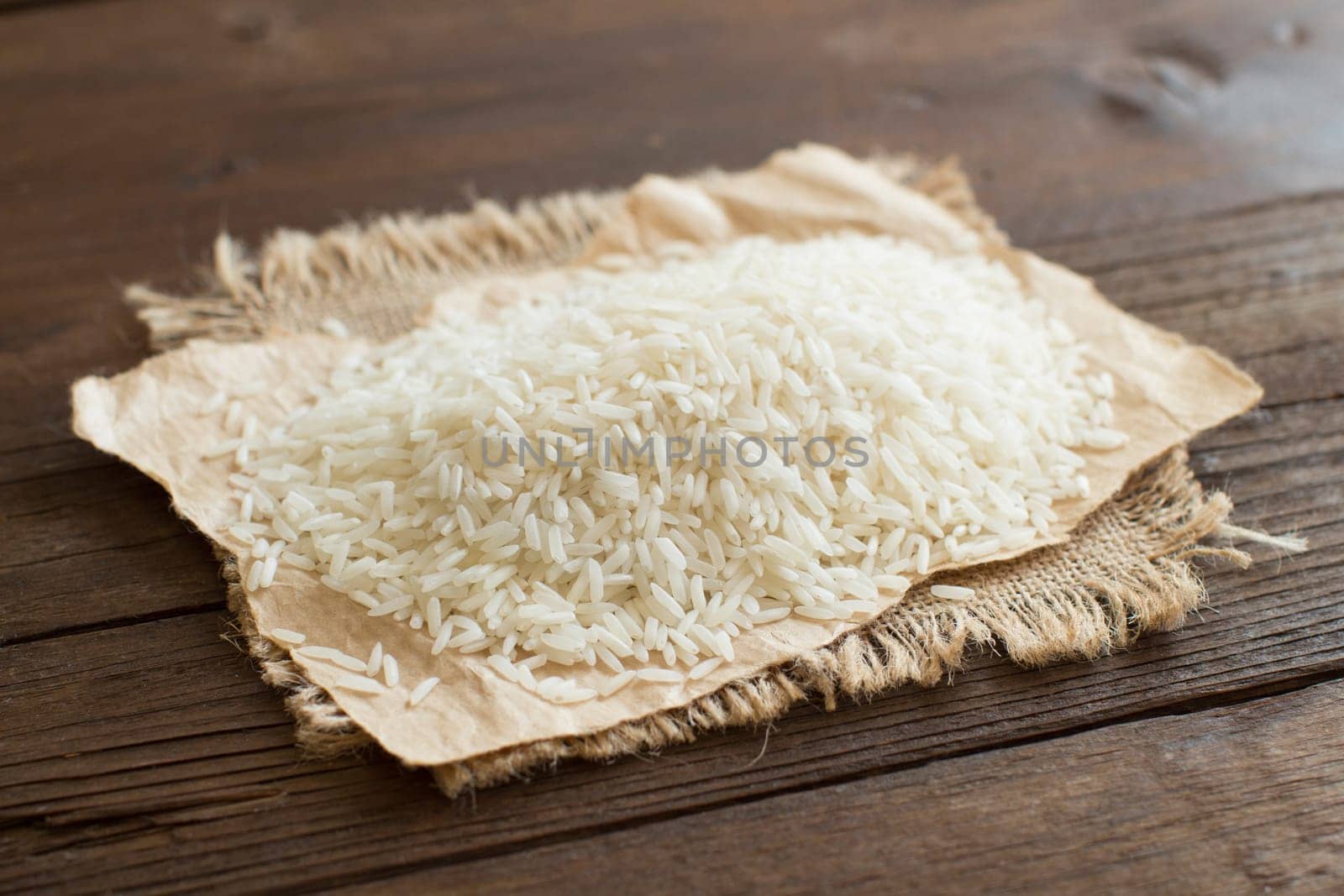 Pile of Basmati rice on a wooden table close up