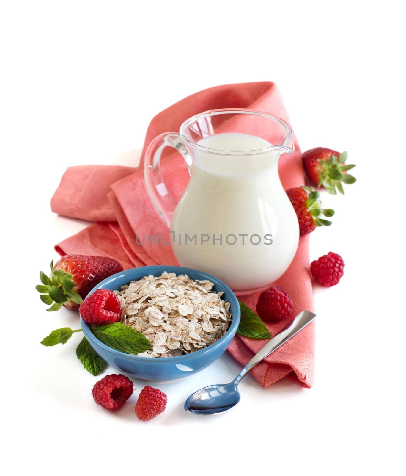 Rolled oats in a bowl with berries and milk isolated on white