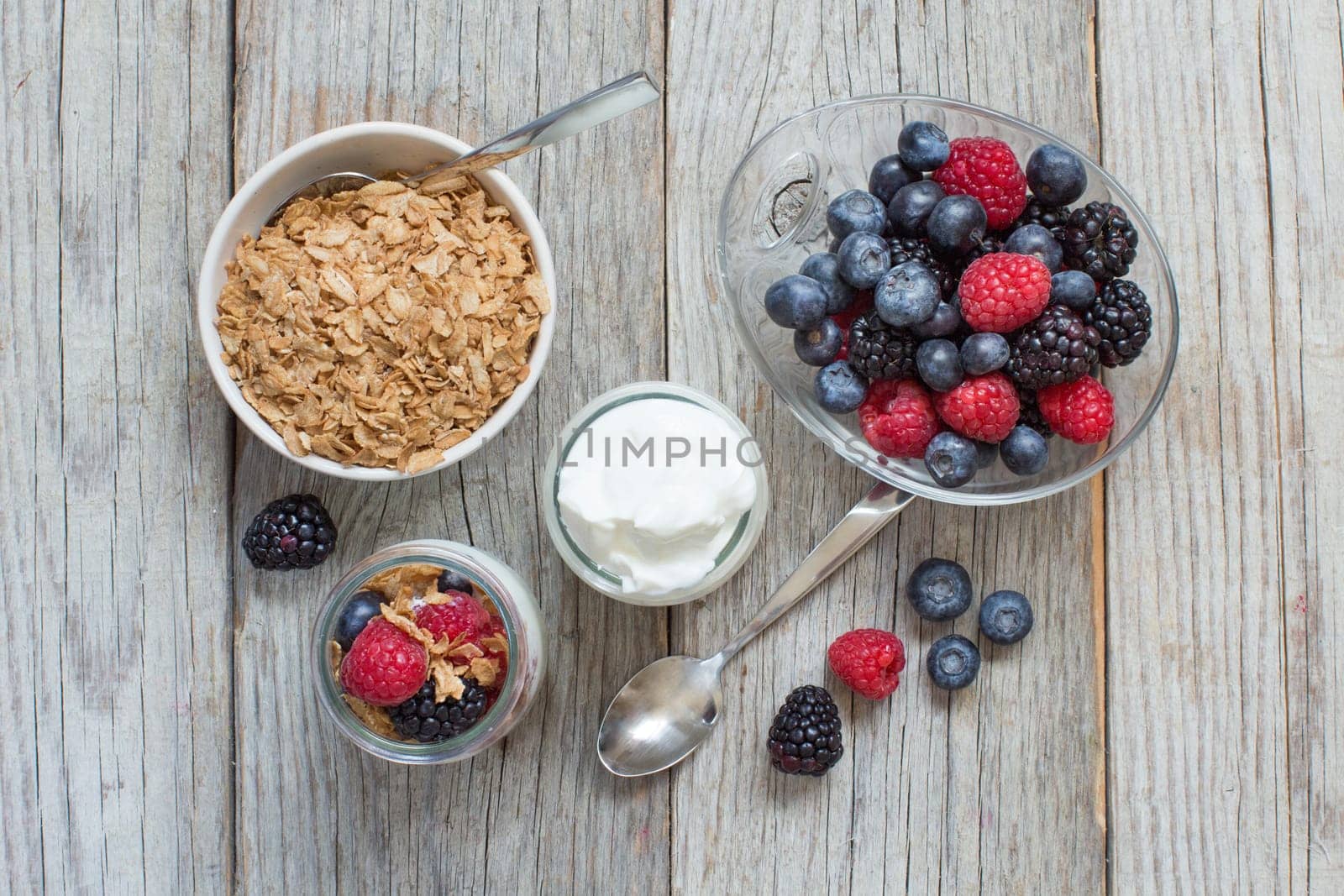 Healthy breakfast with Fresh greek yogurt, flakes and berries on wood