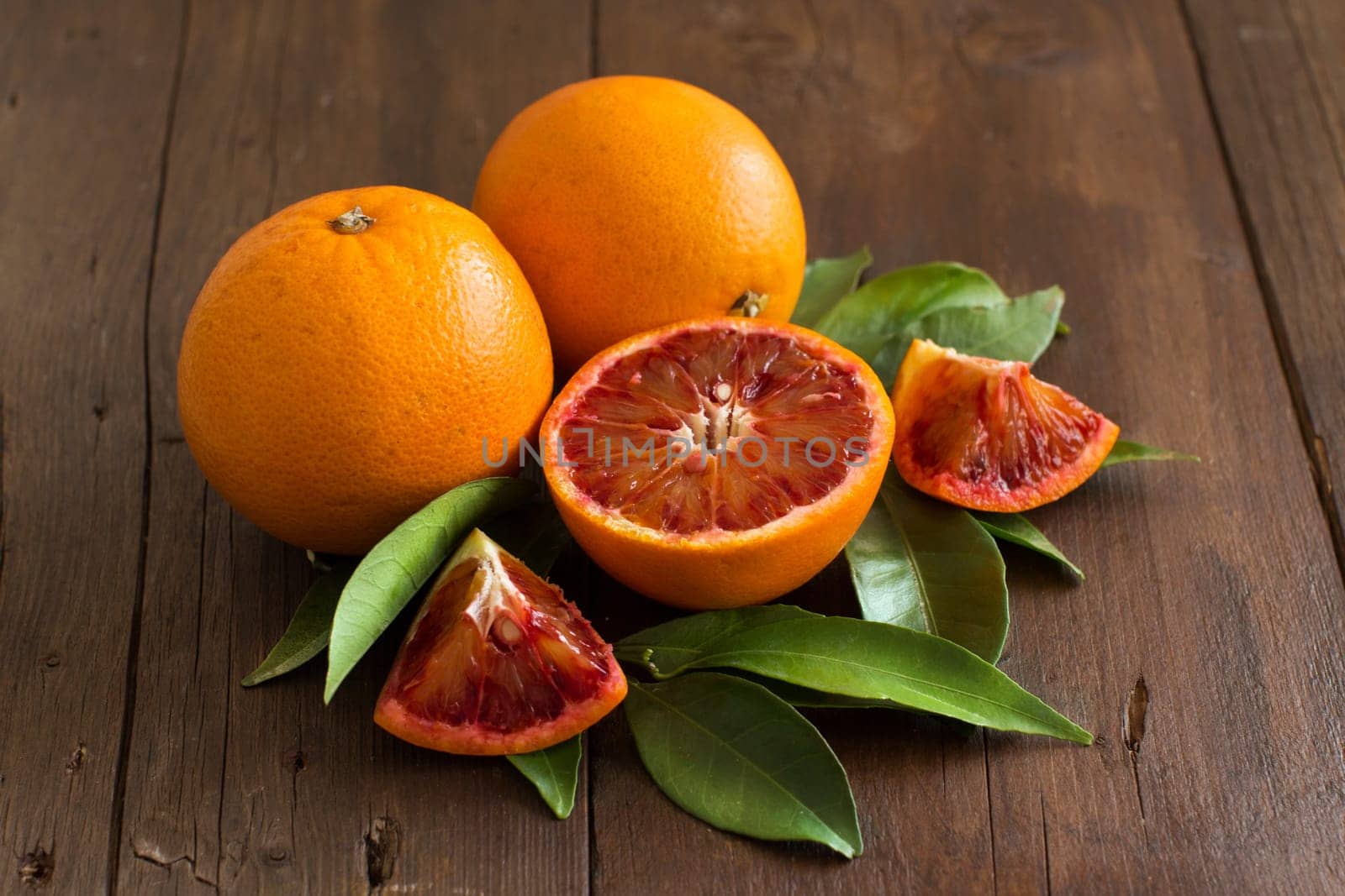 Fresh Sicilian oranges with leaves on a wooden table