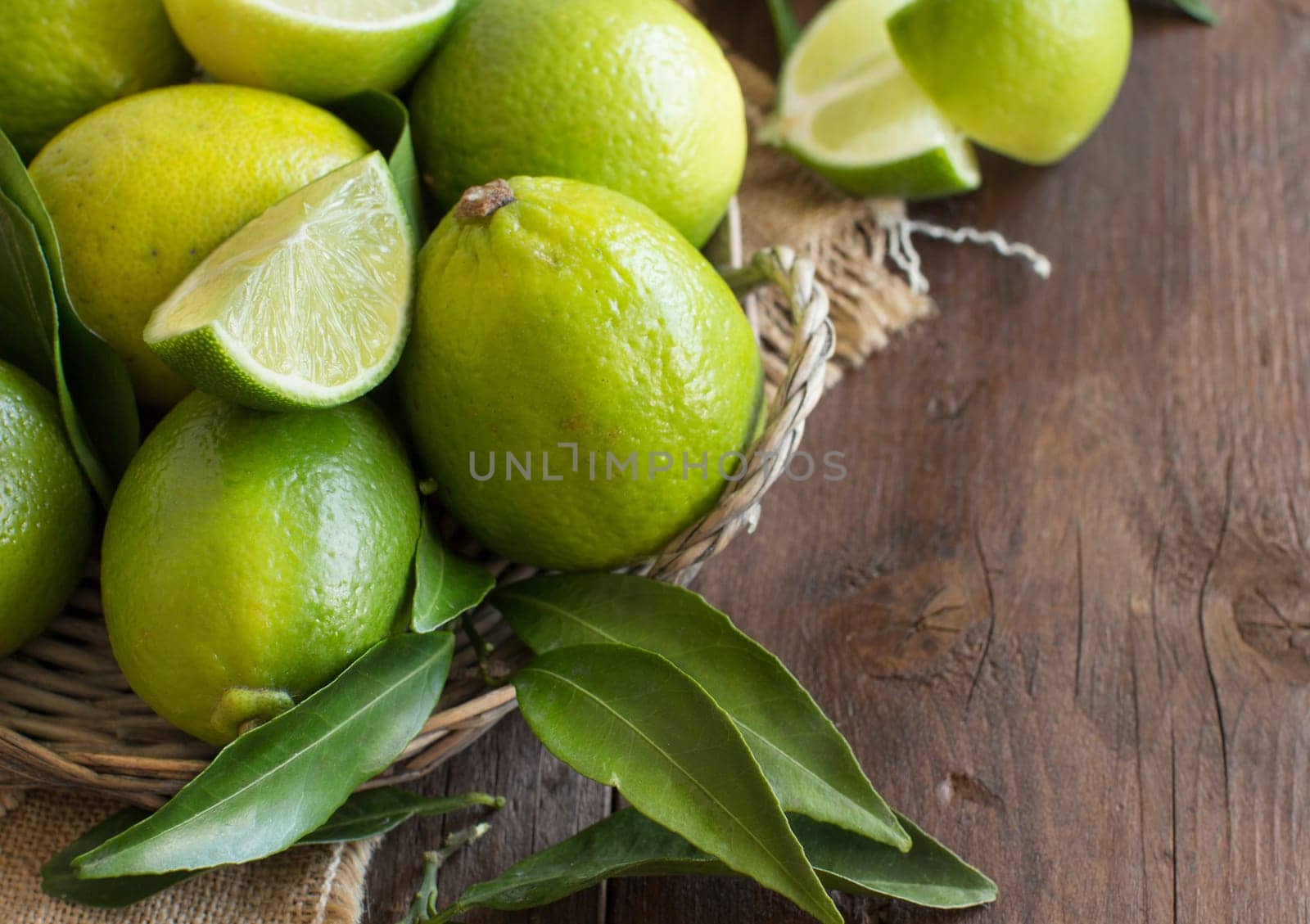Fresh limes with leaves on a wooden table