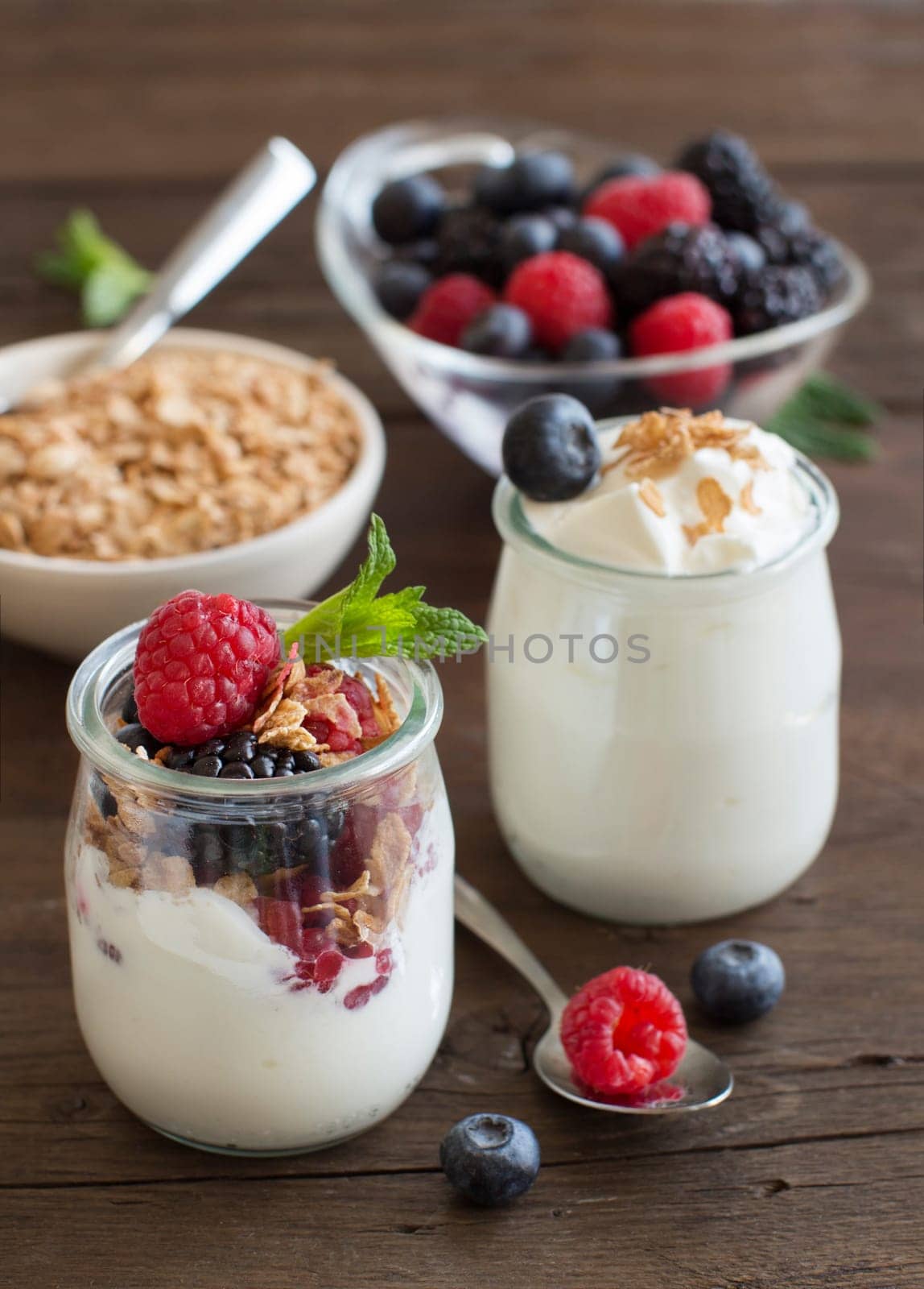 Berries, flakes and fresh greek yogurt on a wooden table
