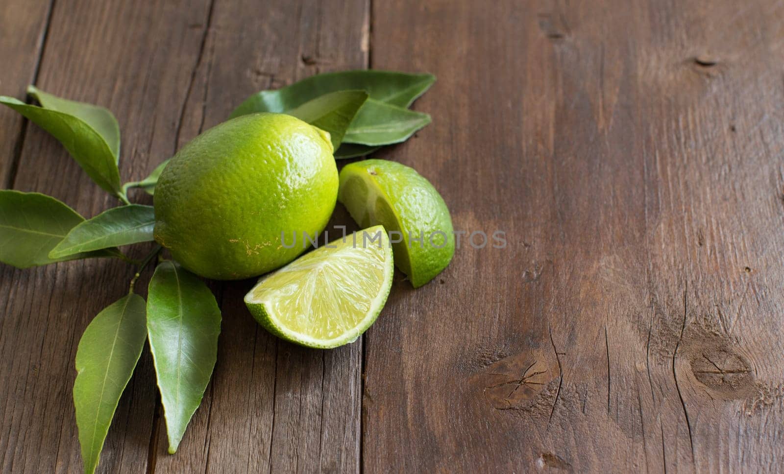 Fresh limes with leaves on a wooden table