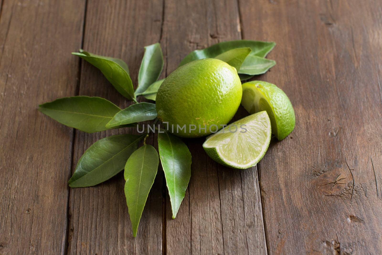 Fresh limes with leaves on a wooden table