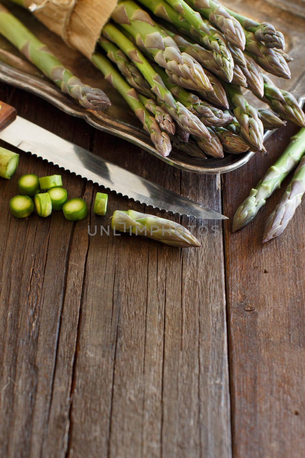 Fresh asparagus with knife on a wooden table