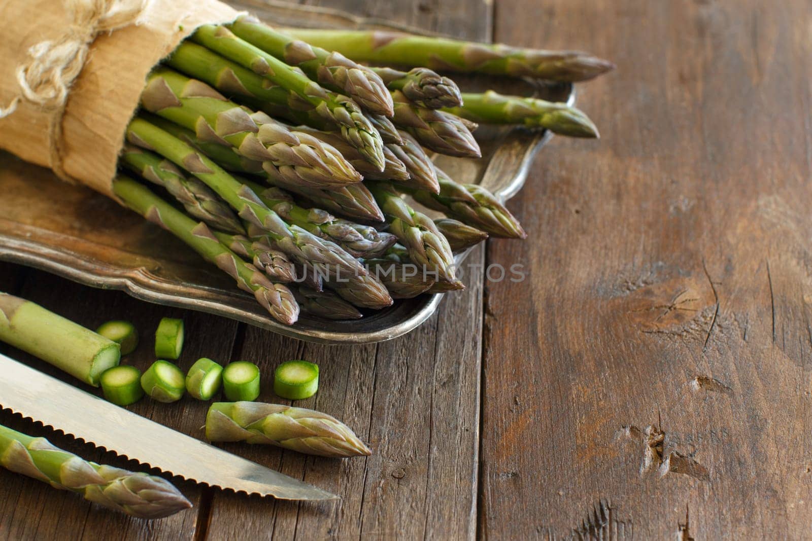Fresh asparagus with knife on a wooden table
