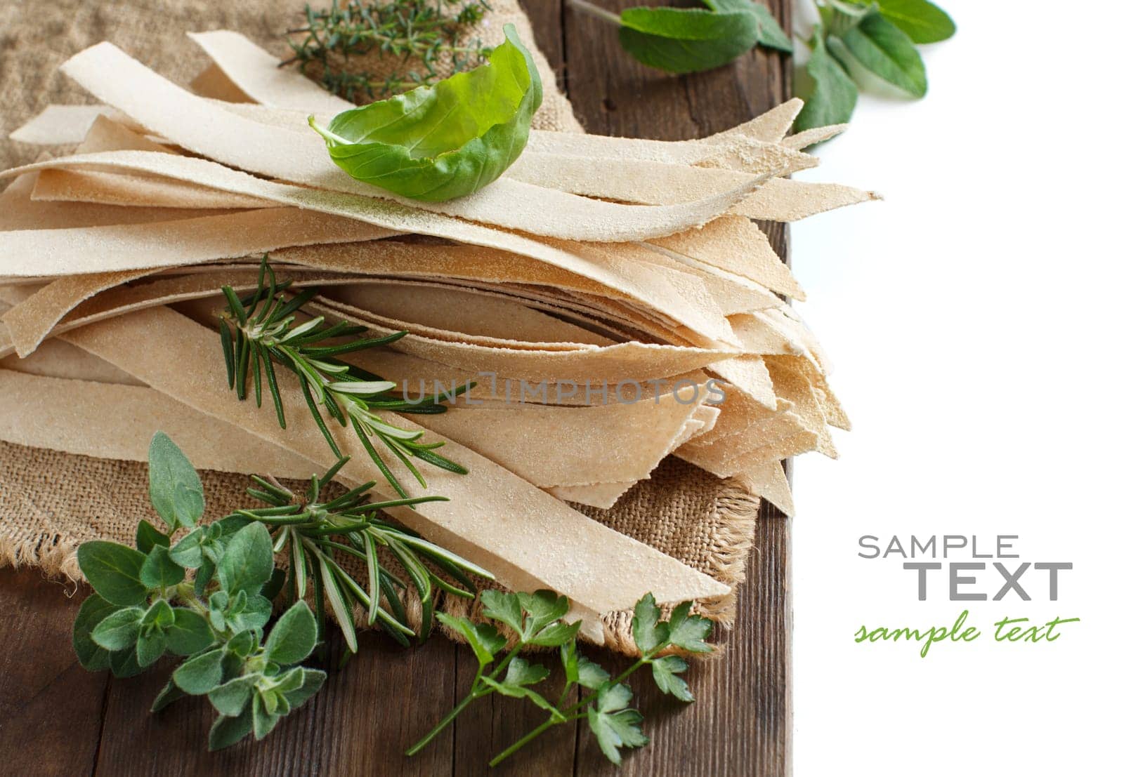 Wholegrain artisan pasta and herbs on old wooden table