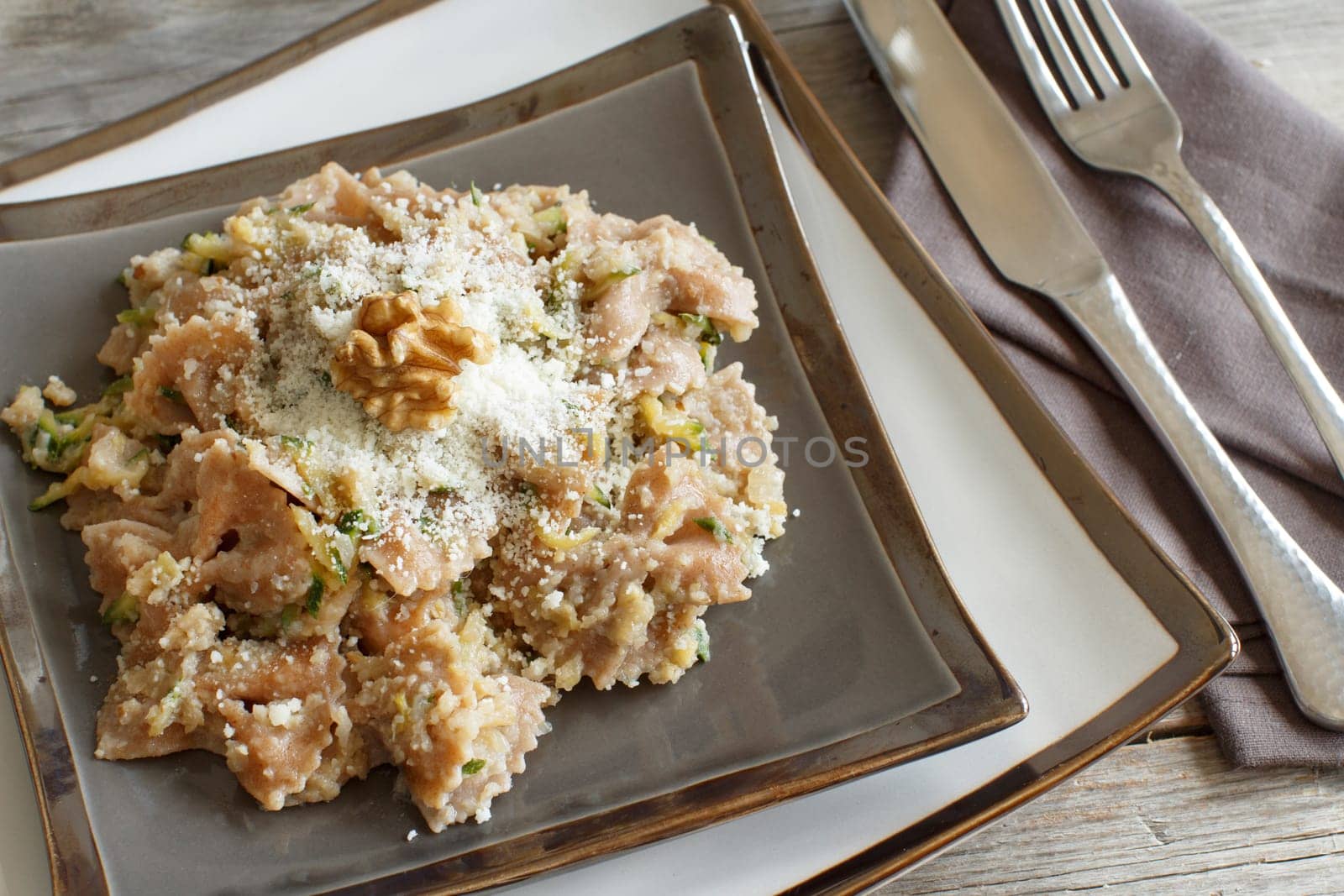 Wholegrain Pasta with topinambur cream, walnuts and zucchine on wood