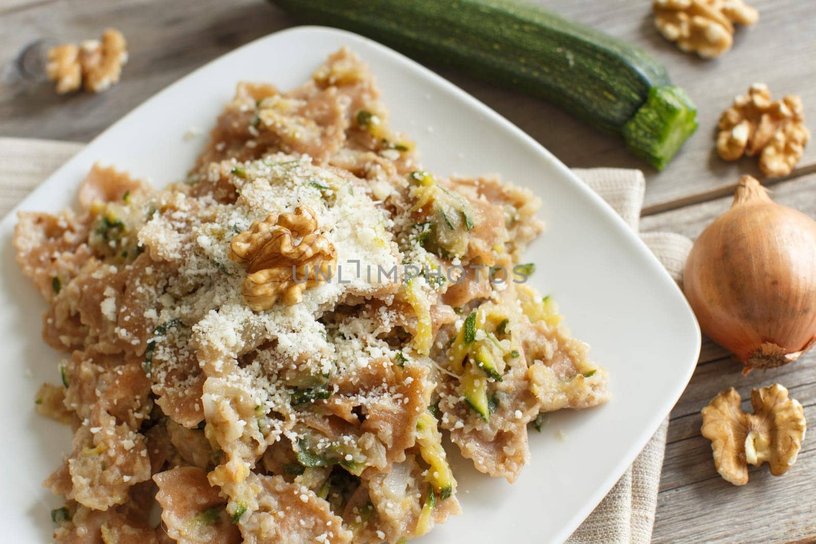 Wholegrain Pasta with topinambur cream, walnuts and zucchine on wood
