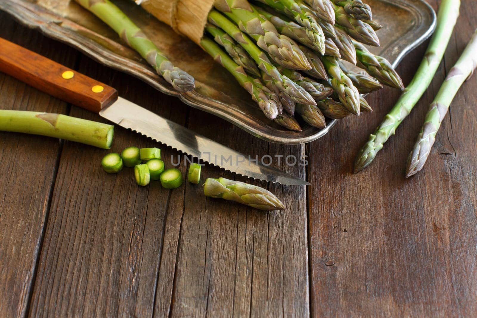 Fresh asparagus with knife on a wooden table