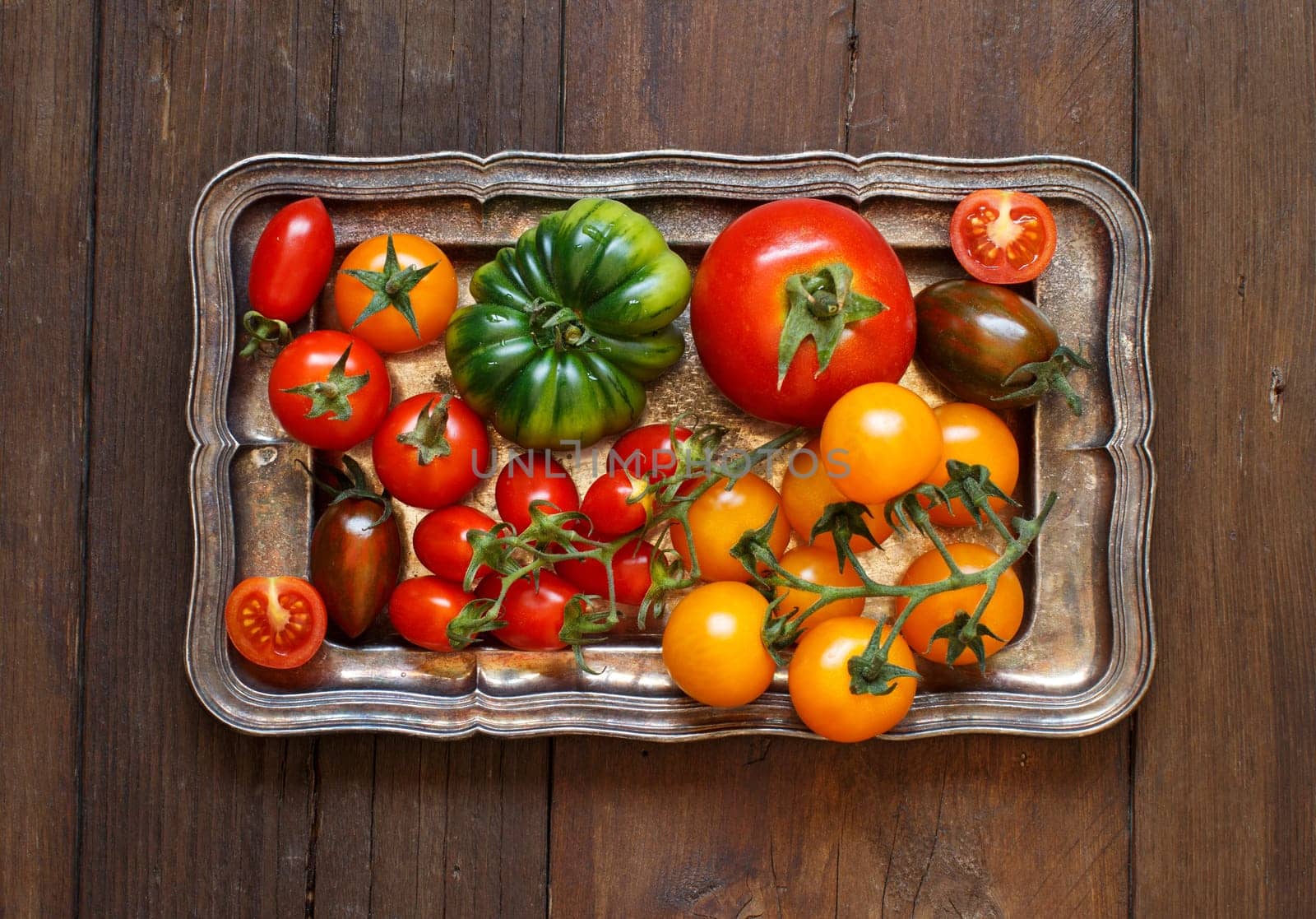 Colorful tomatoes on a metal tray top view
