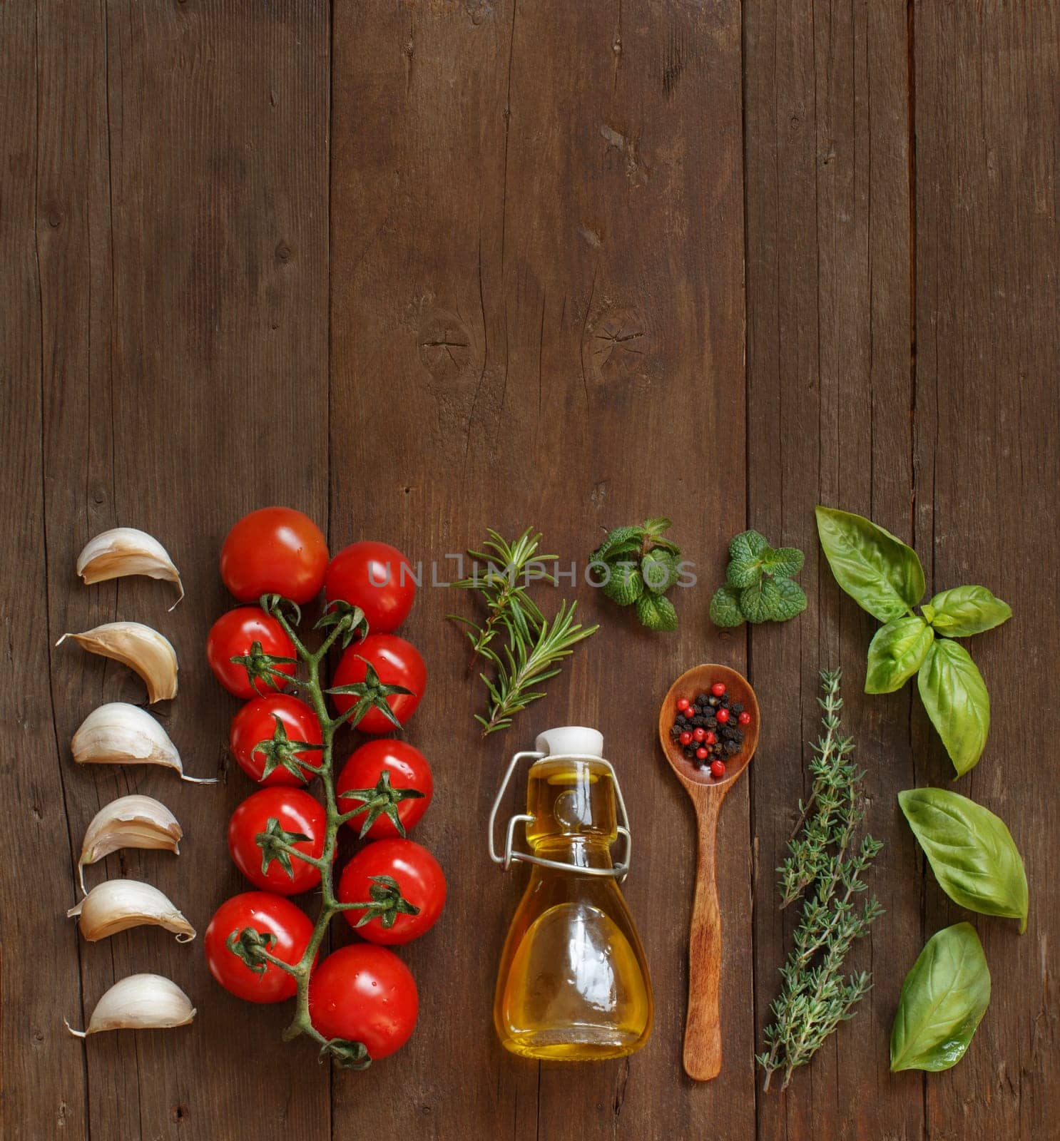 Vegetables, herbs and olive oil on wooden background