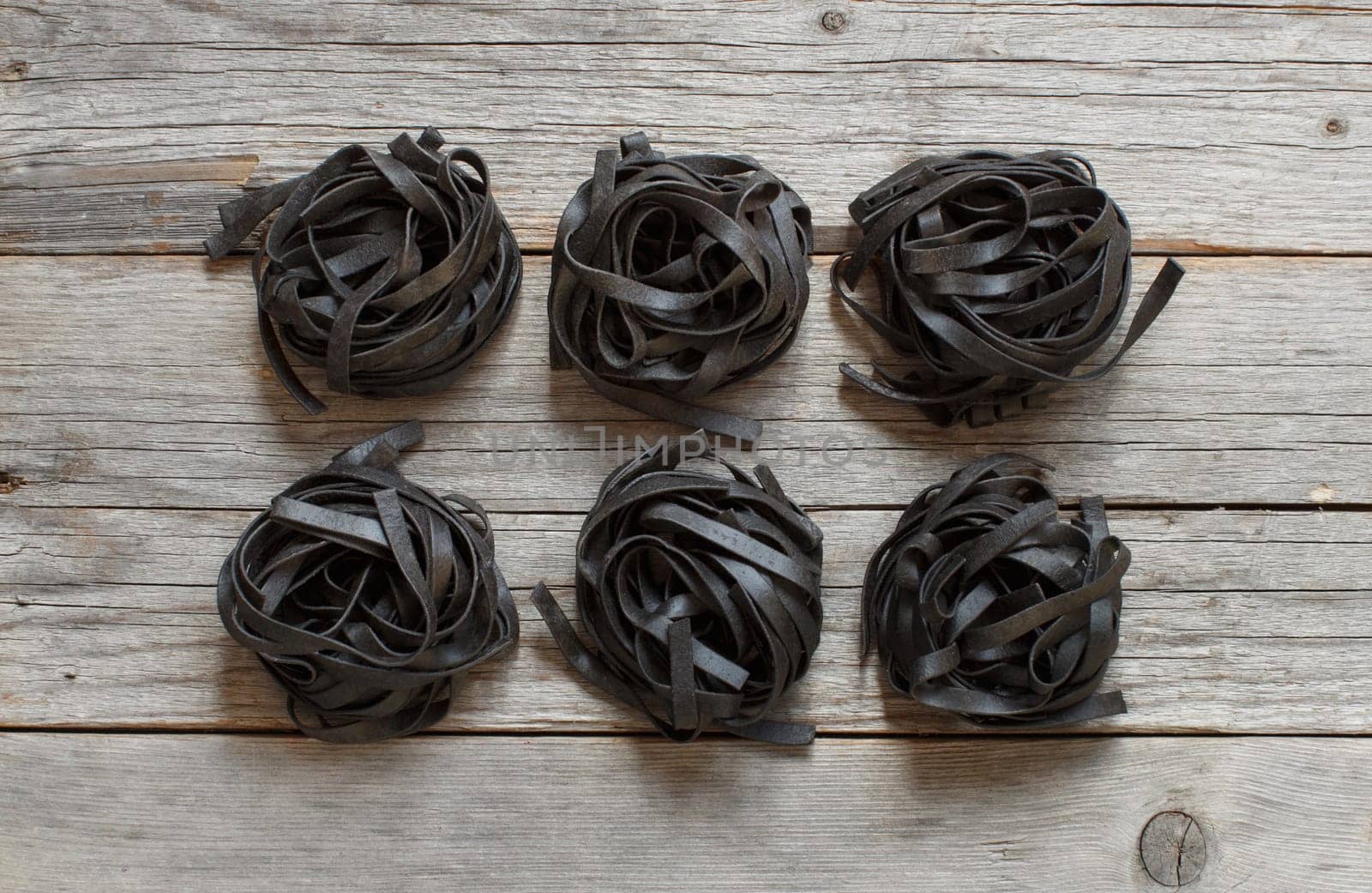 6 Black tagliatelle on an old wooden table