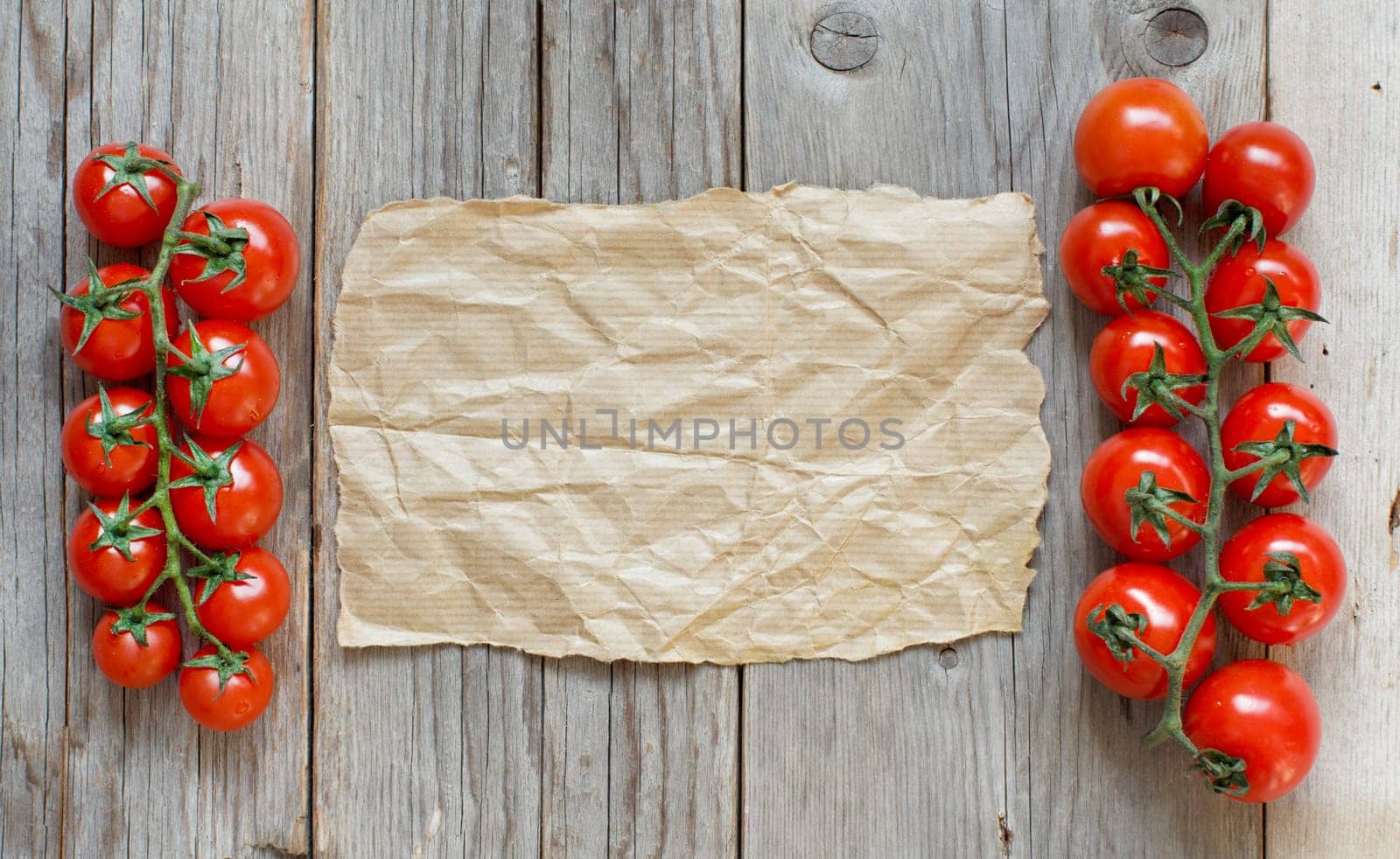 Cherry tomatoes with craft paper on a wooden table background