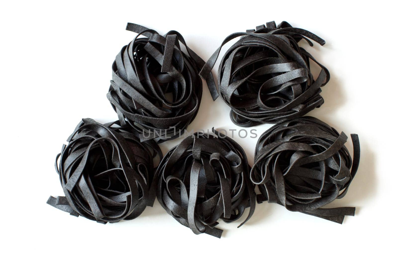 Dry Black Tagliatelle pasta isolated on white background