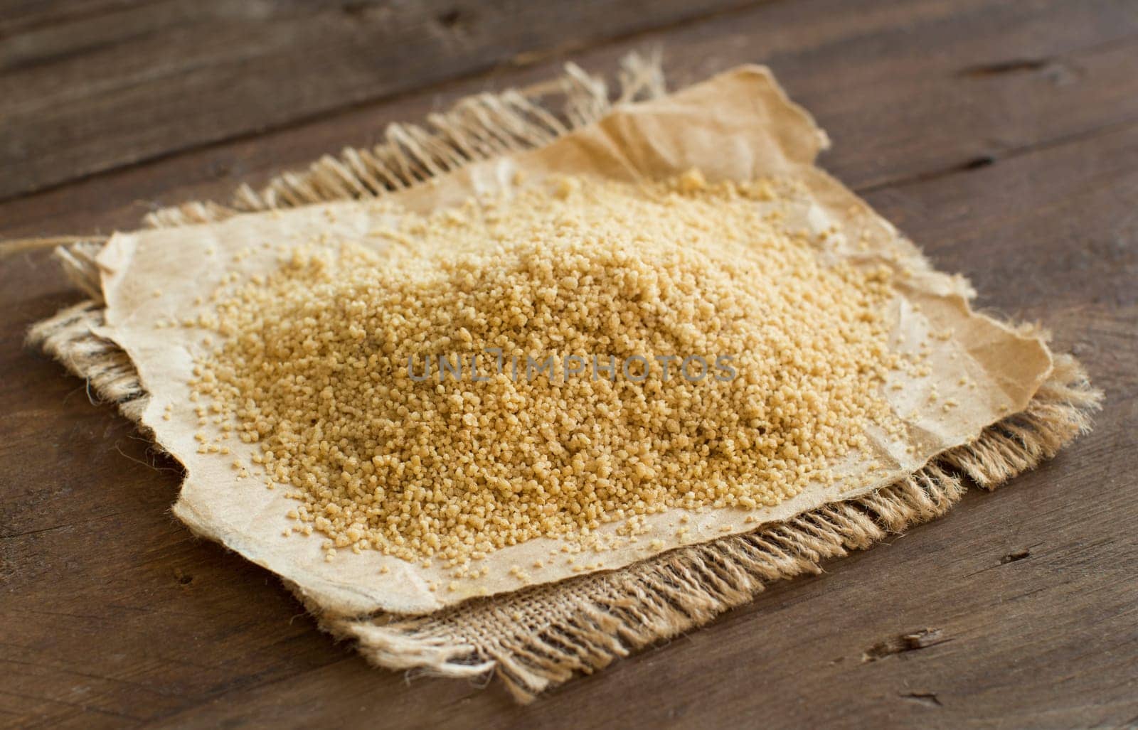 Pile of whole wheat CousCous on wood