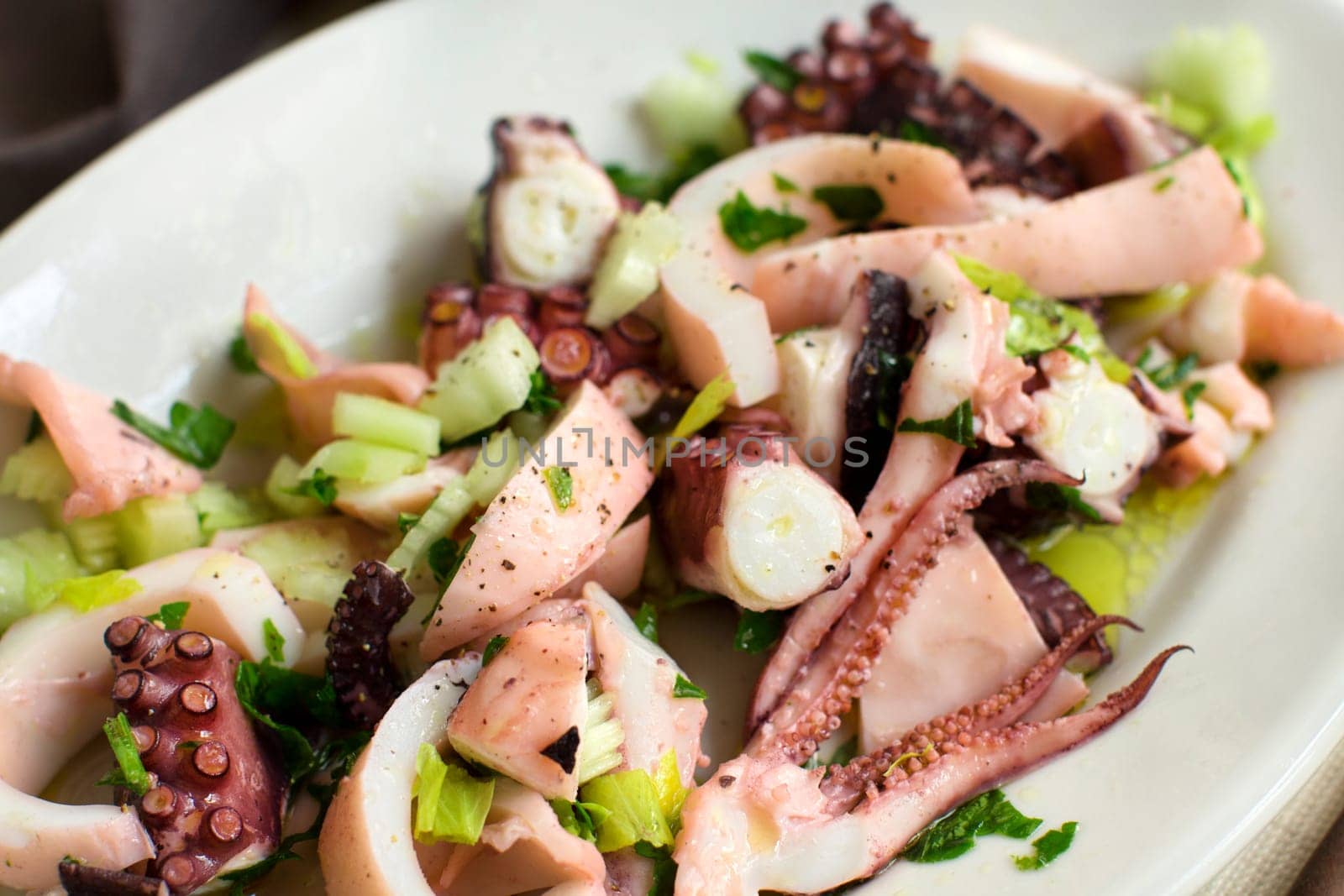 Seafood salad made of different seafood and vegetables close up