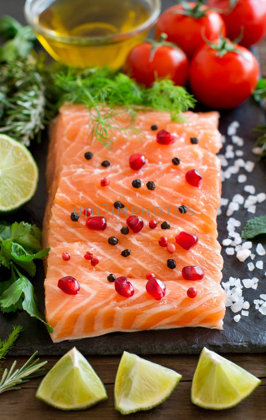 Salmon with vegetables, olive oil and herbs on wood