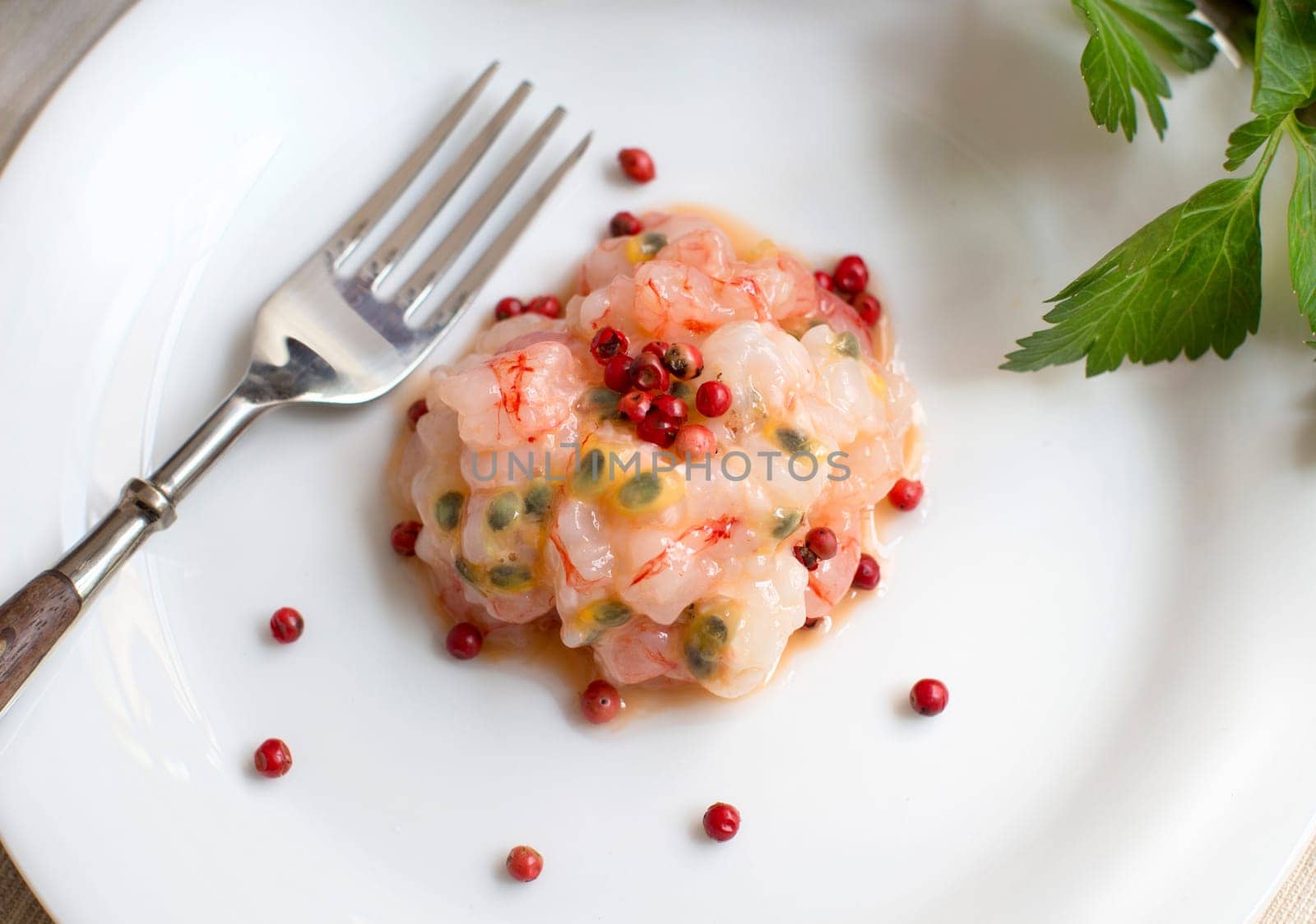 Delicious raw shrimps tartare with passion fruit and pink pepper