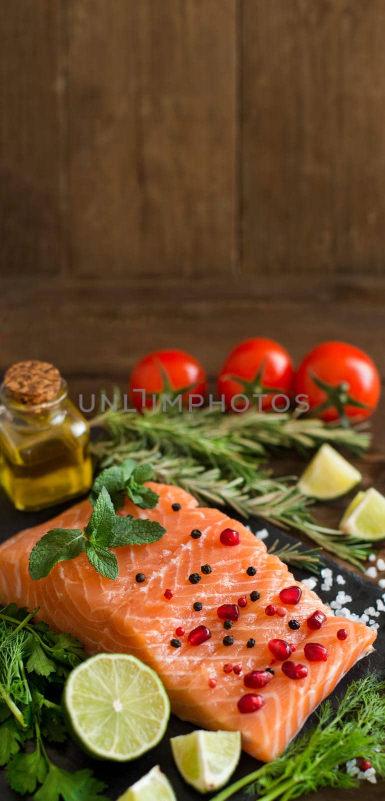 Salmon with vegetables, olive oil and herbs on wood