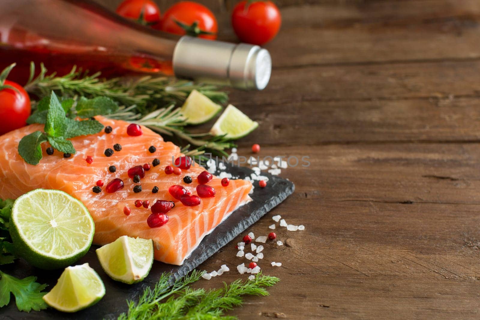 Salmon with vegetables, olive oil and herbs on wood