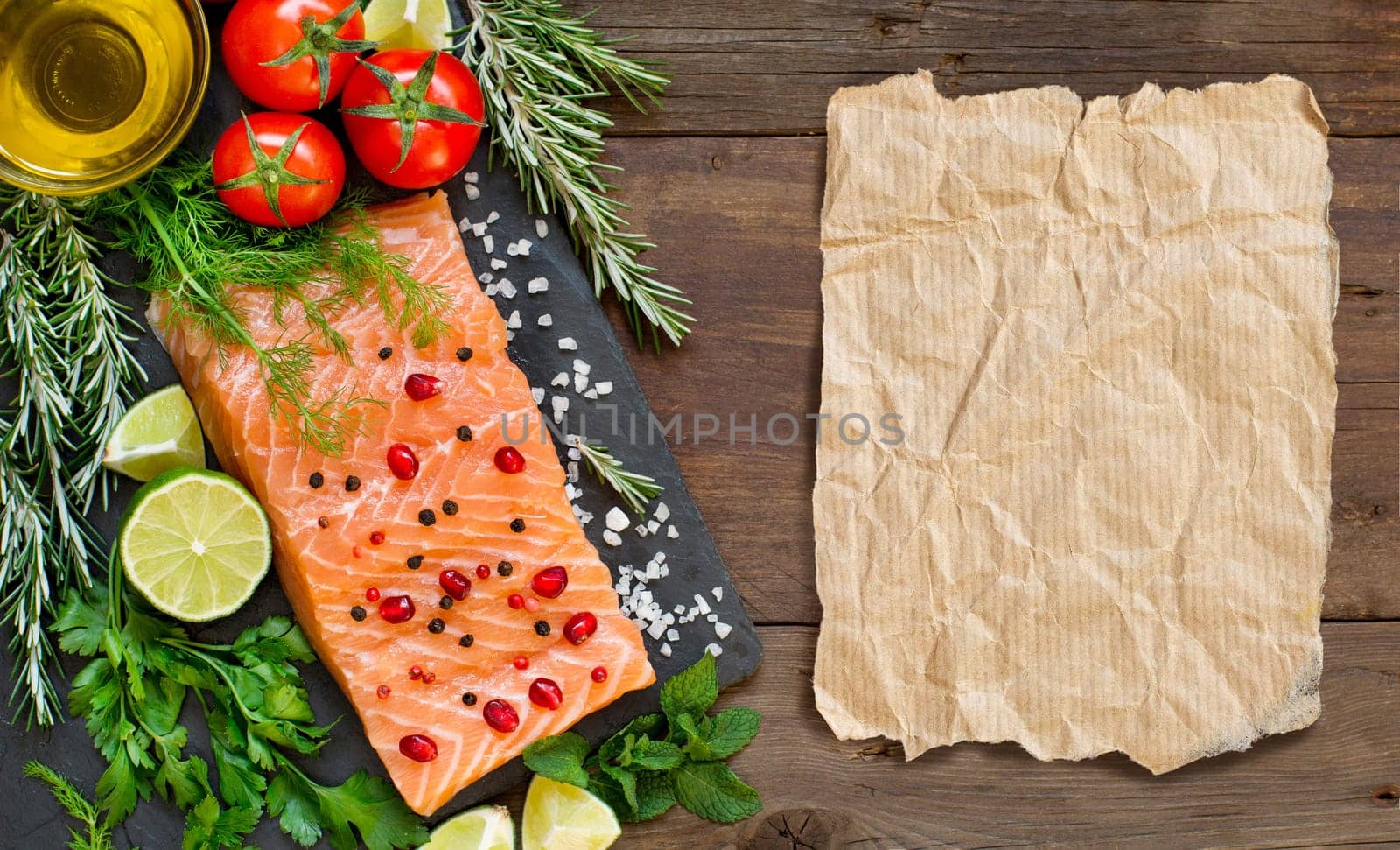Salmon with vegetables and herbs on wooden background