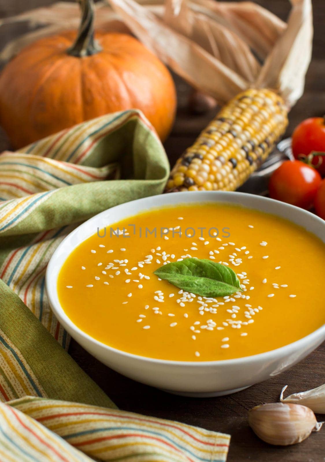 Fresh pumpkin soup and vegetables on a wooden table