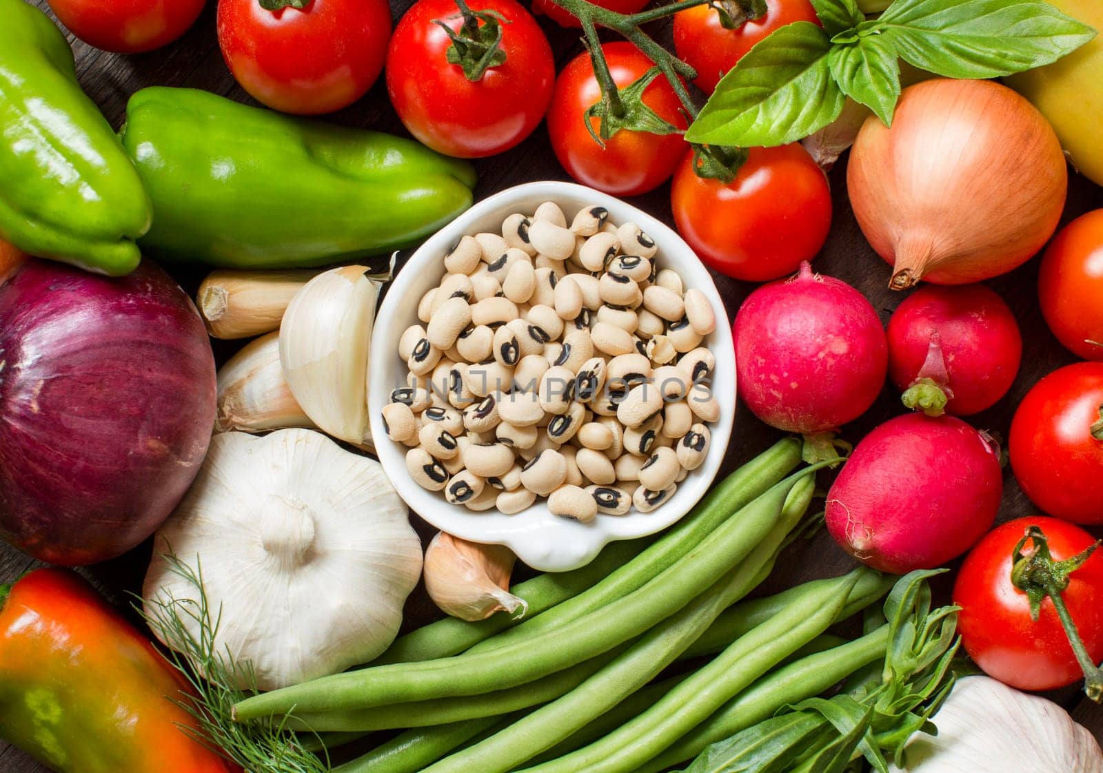 Black eyed peas in a bowl and vegetables top view