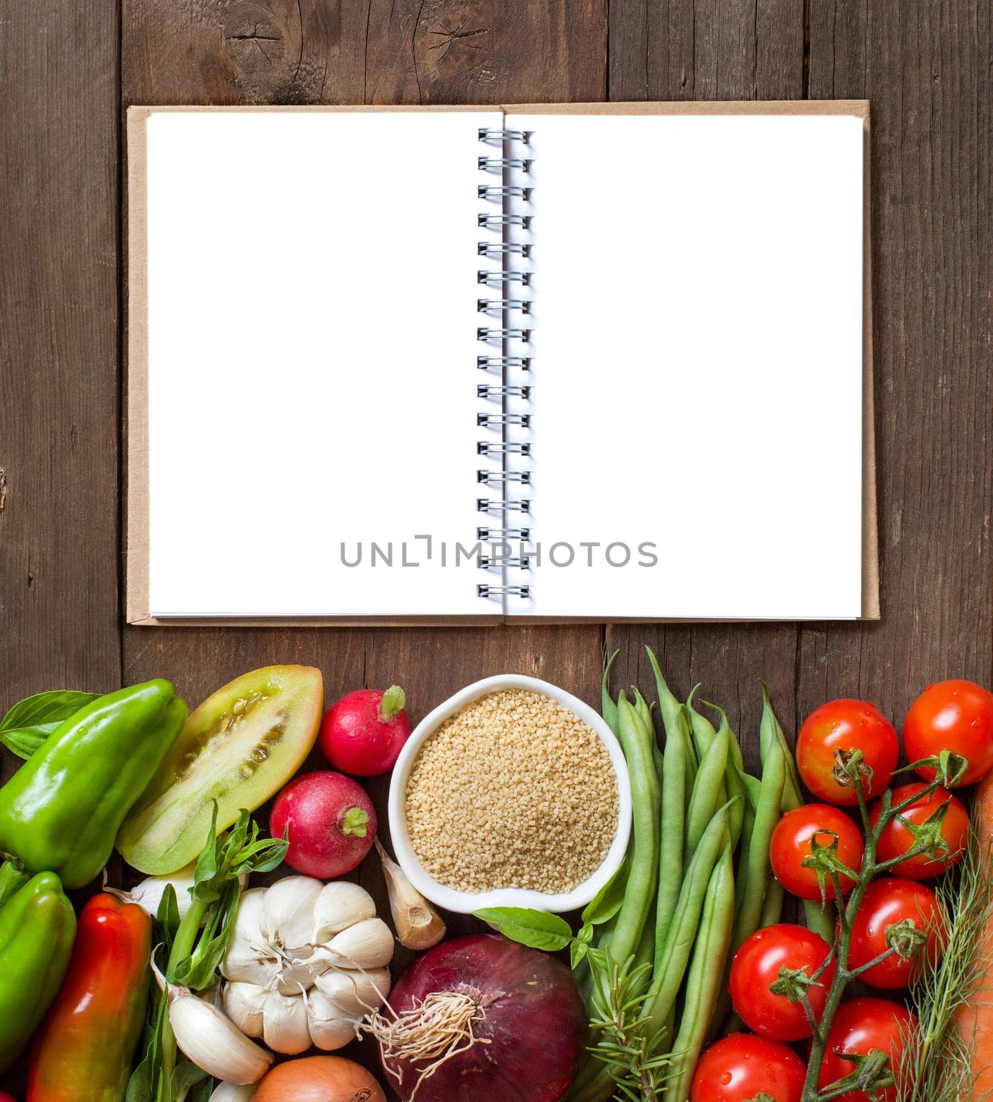 CousCous in a bowl and fresh vegetables on wood