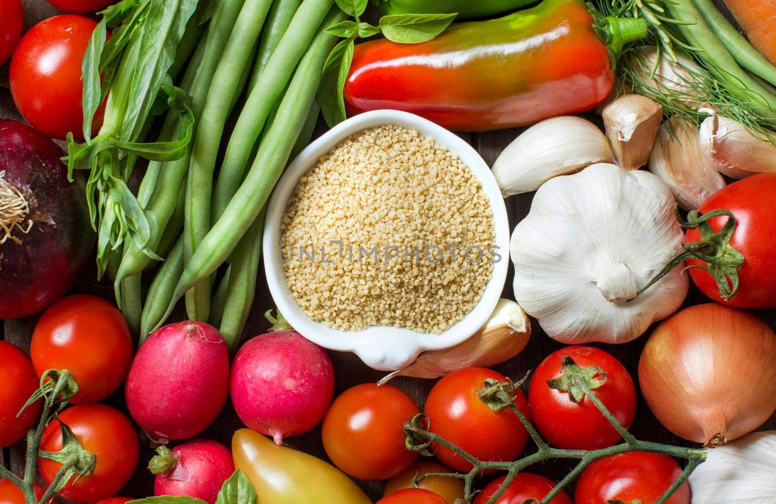 CousCous in a bowl and fresh vegetables closeup