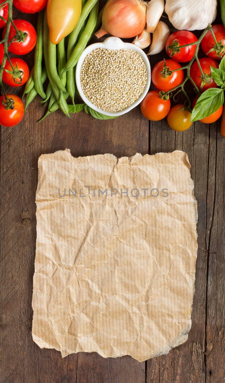 Quinoa in a bowl and fresh vegetables on a wooden table
