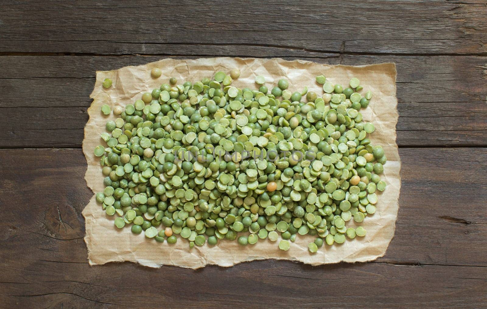 Dried Green Split Peas on a craft paper on wood