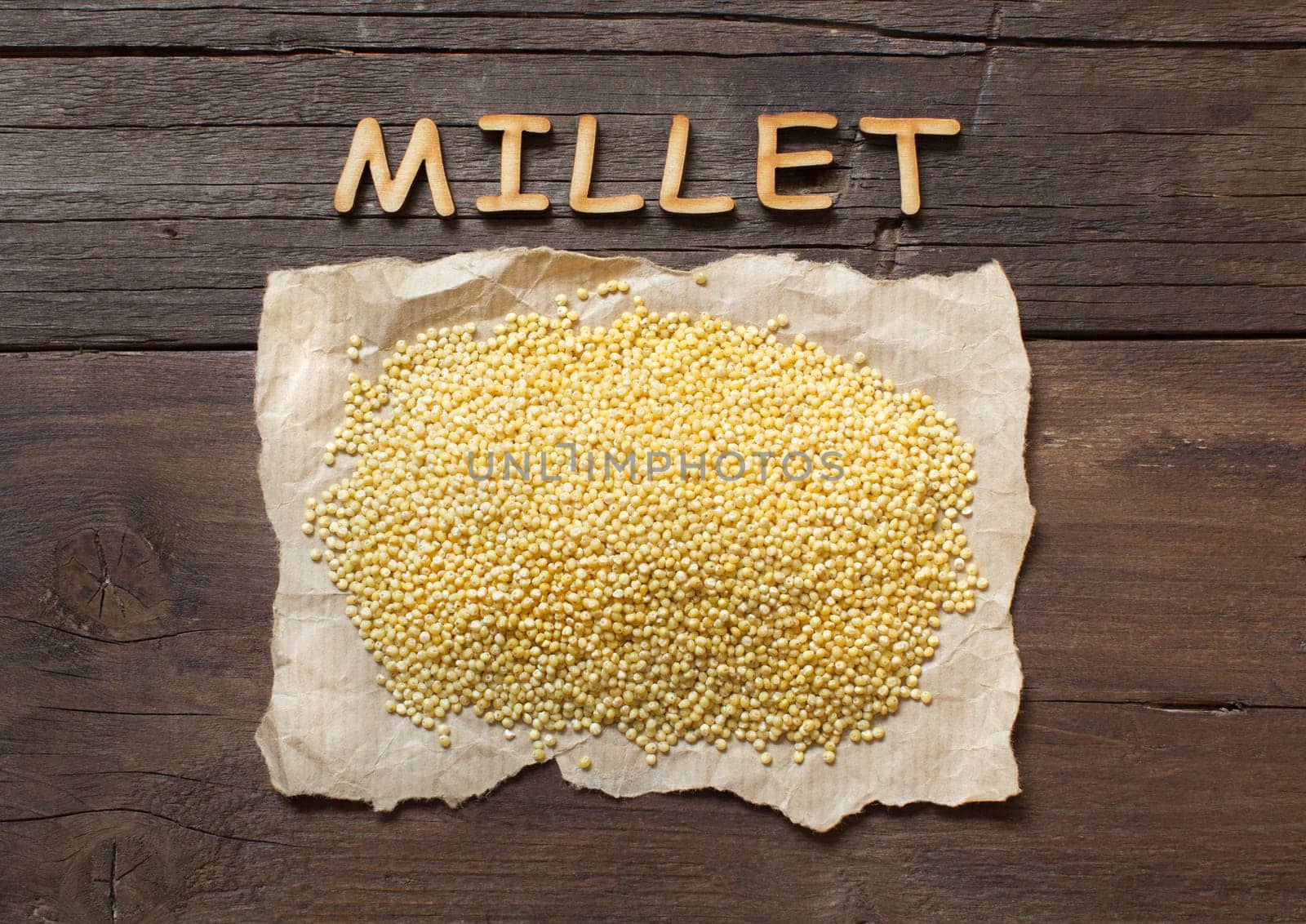 Raw millet on a craft paper with a word Millet