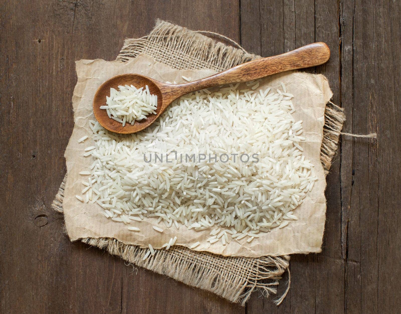 Basmati rice with a spoon on an dark wood