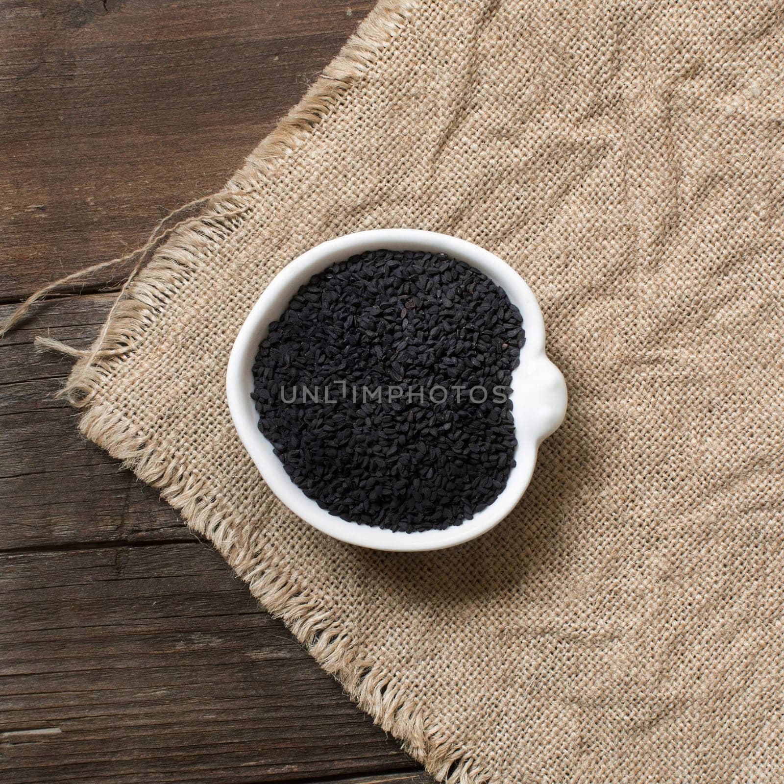 Nigella sativa or Black cumin in a bowl on a wooden background