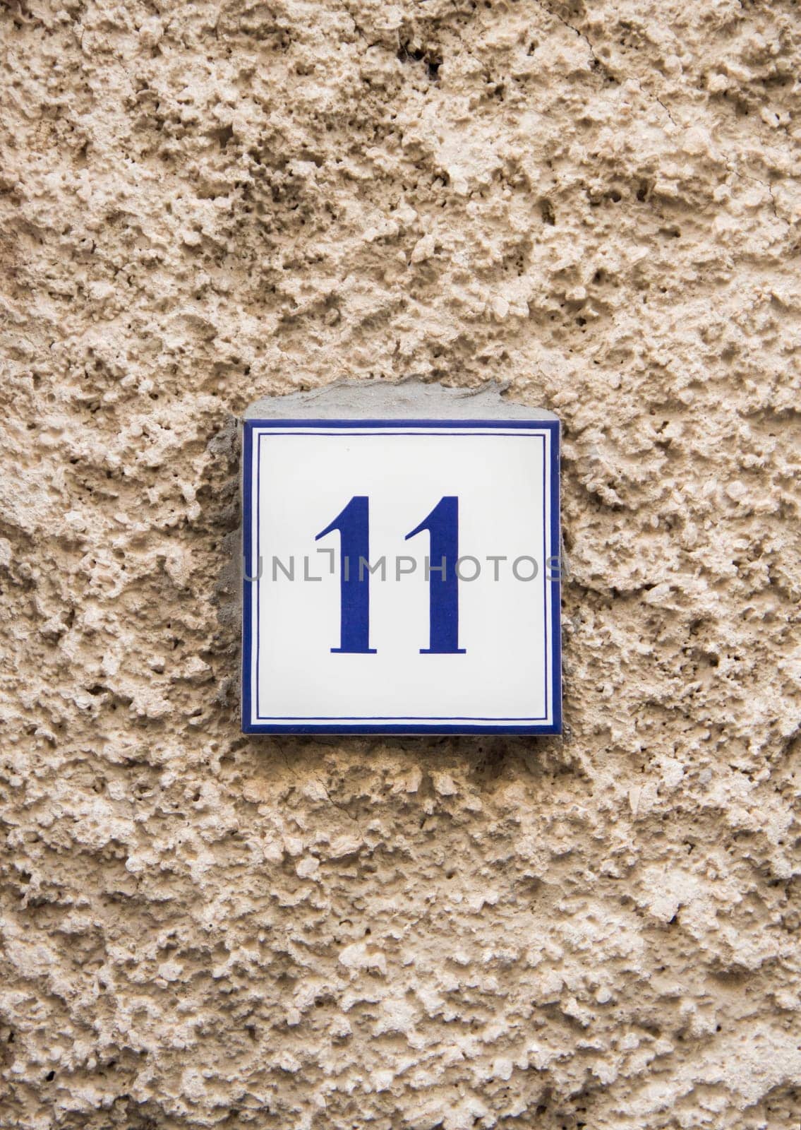 Ceramic number eleven on the grey stone wall