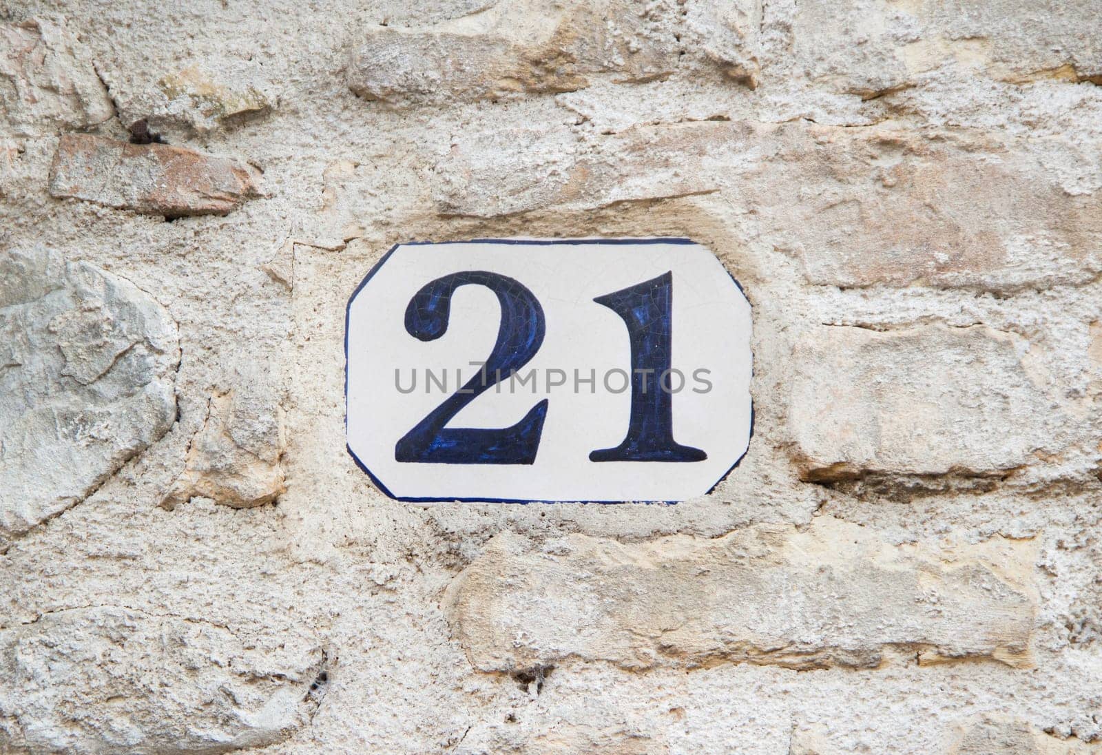 Ceramic number twenty one on the grey stone wall