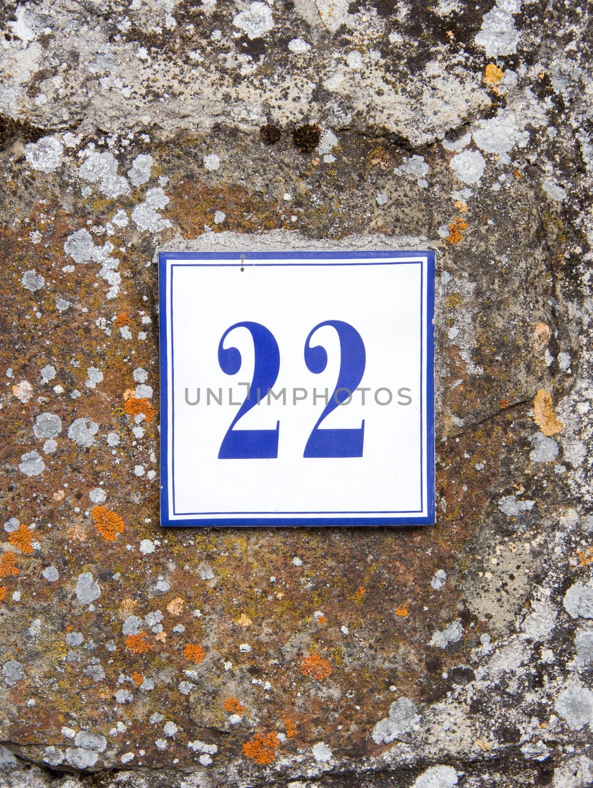 Ceramic number twenty two on the grey stone wall