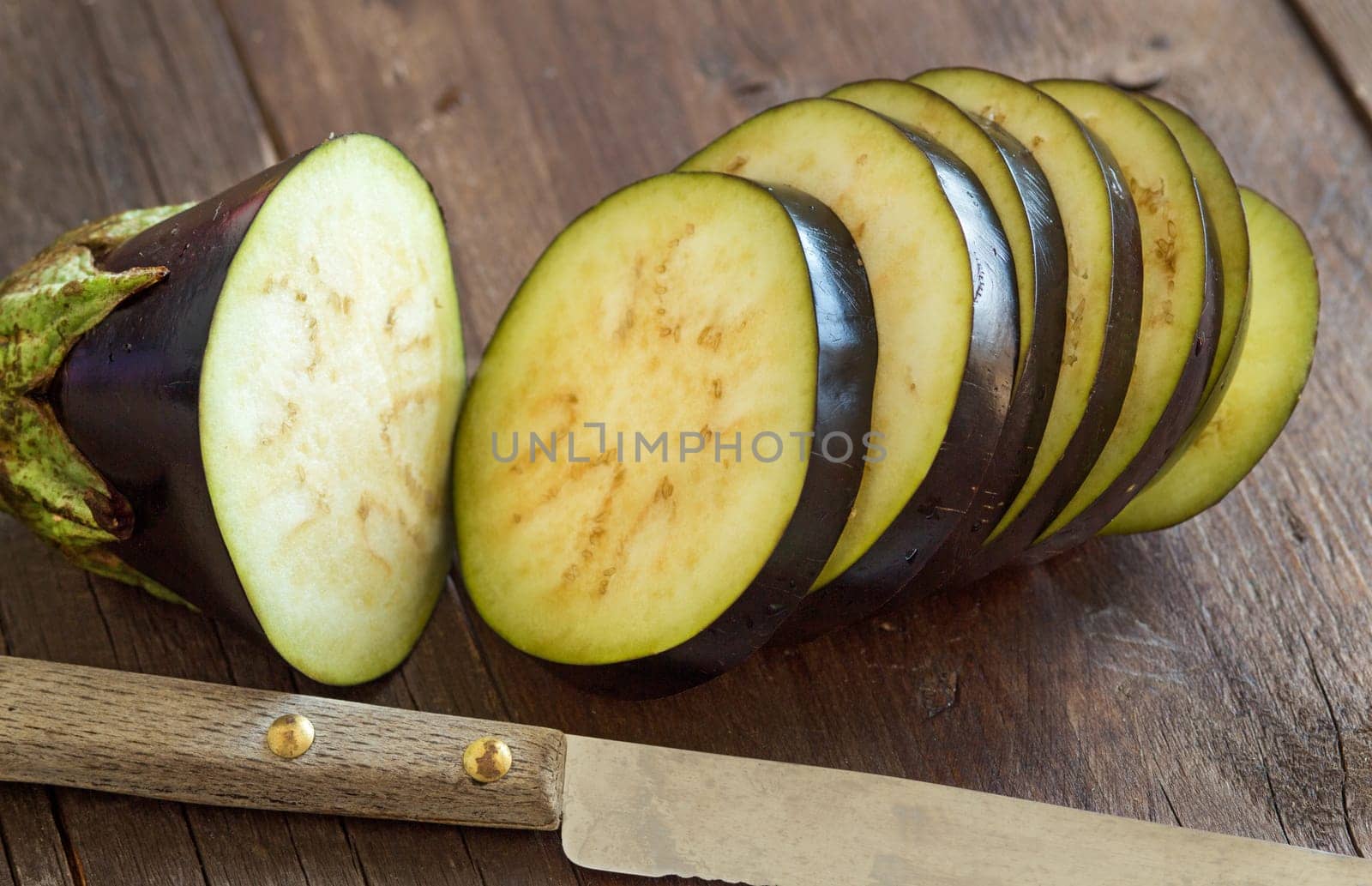 Fresh Raw eggplants with knife on the wood background