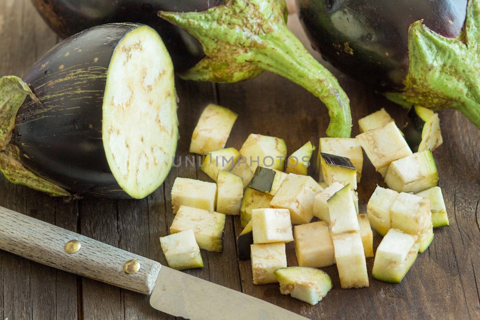 Fresh Raw eggplants with knife on the wood background