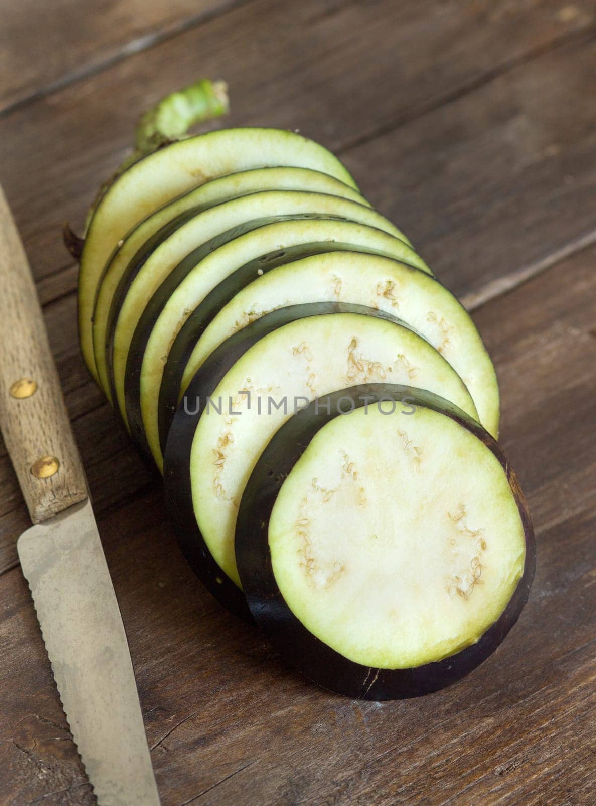 Fresh Raw eggplants with knife on the wood background