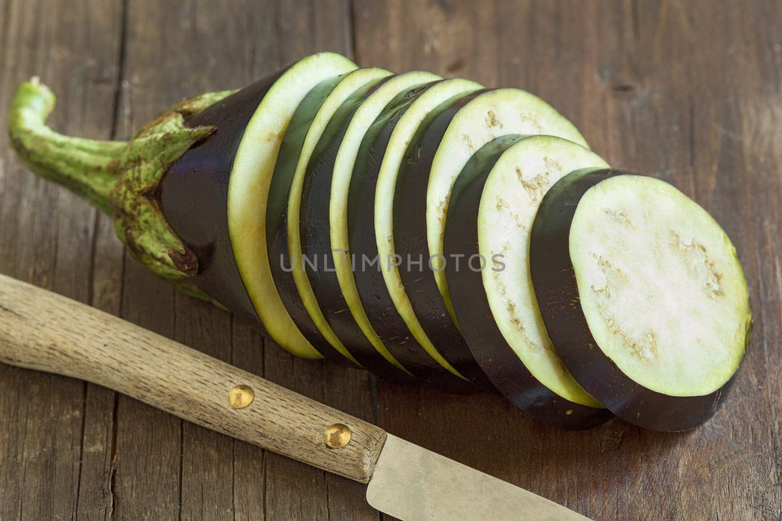 Fresh Raw eggplants with knife on the wood background
