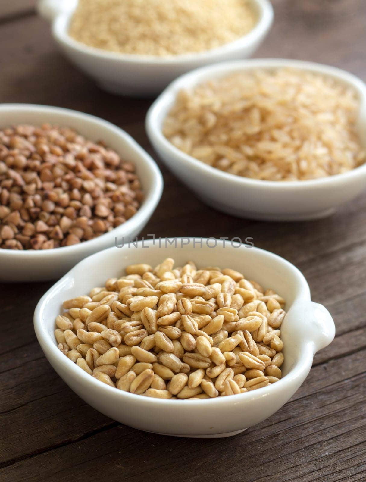 Cereals in bowls on wood close up